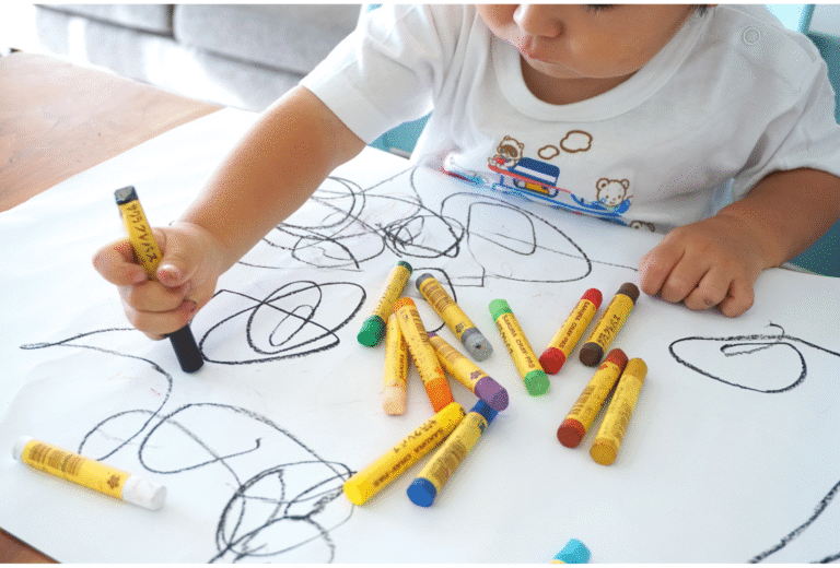 Toddler scribbling with crayons. Why choose scribble & giggle featured image